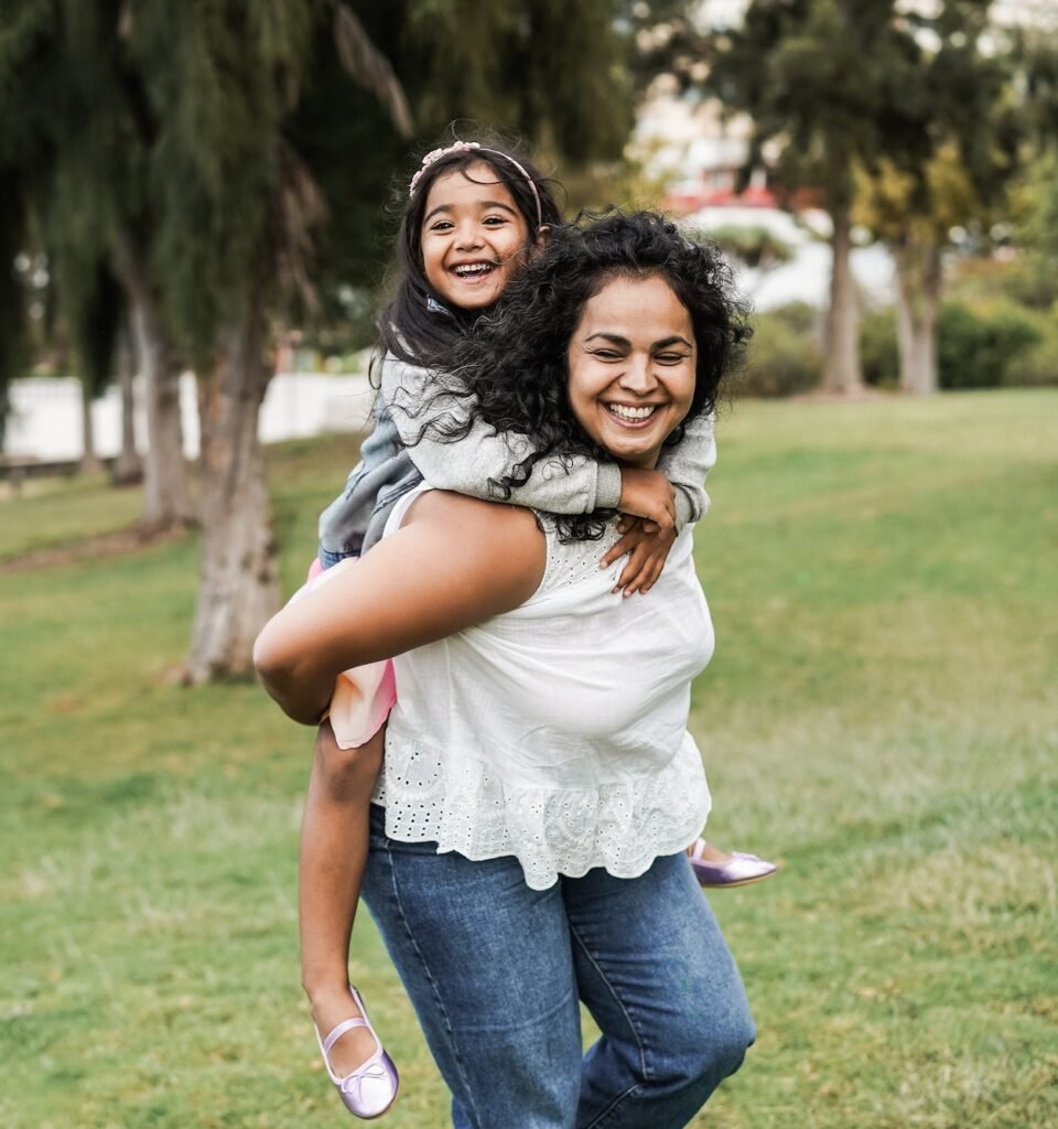 Happy indian mother having fun with her daughter outdoor - Focus on mother face